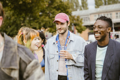 Portrait of smiling friends standing against trees