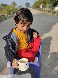 Cute girl with drink sitting outdoors