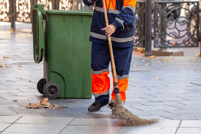 Low section of man standing on sidewalk