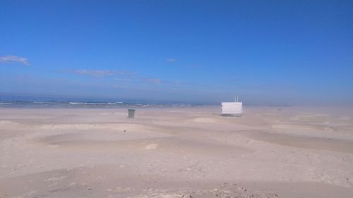 Scenic view of beach against blue sky