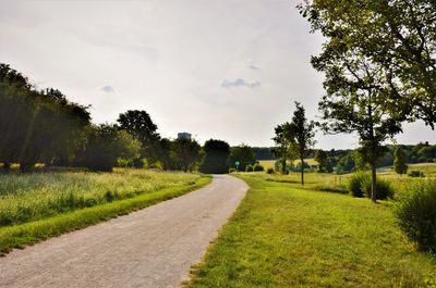 Road amidst field against sky