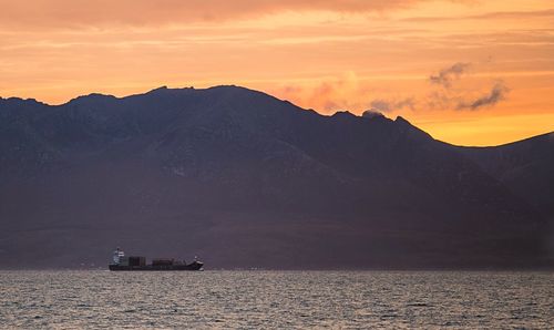 Scenic view of lake against mountains during sunset