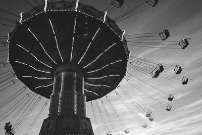 Low angle view of chain swing ride against sky