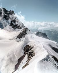 Scenic view of snow covered mountains against sky