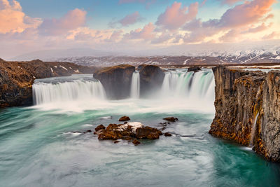 Scenic view of waterfall against sky