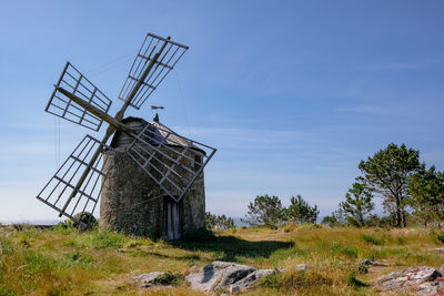 Traditional windmill on field against sky