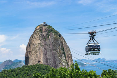 Low angle view of overhead cable car against sky