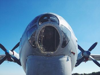 Low angle view of airplane flying against clear blue sky