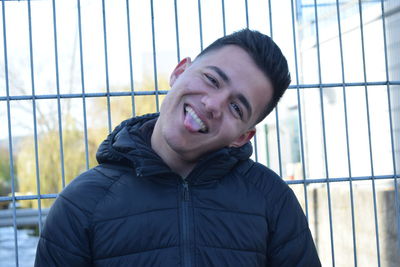 Portrait of smiling young man against window