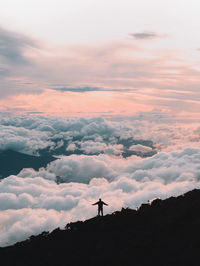 Silhouette man standing on land against sky during sunset