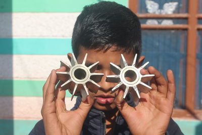 Close-up portrait of boy holding camera