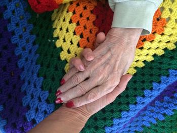 Granddaughter holding grandmother's hand preceding final stage of life.