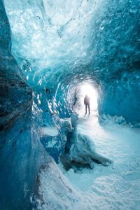 Silhouette woman standing in frozen cave