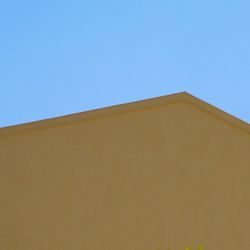 Low angle view of building against clear blue sky