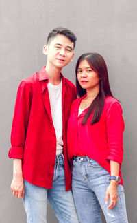 Portrait of smiling friends standing against wall