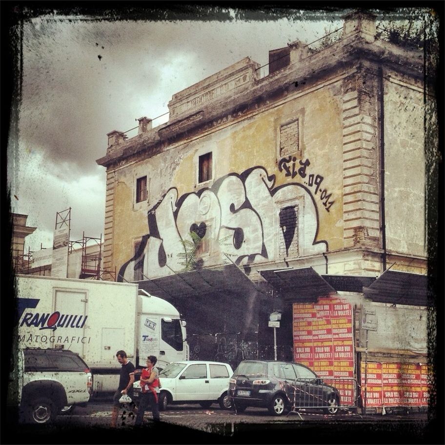 building exterior, architecture, transfer print, built structure, auto post production filter, sky, street, cloud - sky, men, graffiti, city, land vehicle, building, residential structure, transportation, residential building, outdoors, cloud, day