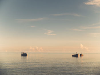 Boats sailing in sea against sky