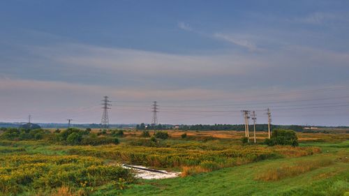 Electricity pylon on field against sky