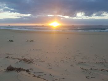 Scenic view of beach against sky during sunset