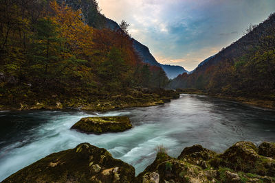 Scenic view of river amidst mountains against sky