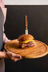 Appetizing cheeseburger with a knife on a board