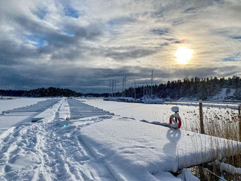 Person on snow covered field against sky