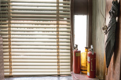 Fire extinguishers by blinds in room