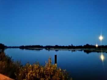 Scenic view of lake against clear blue sky