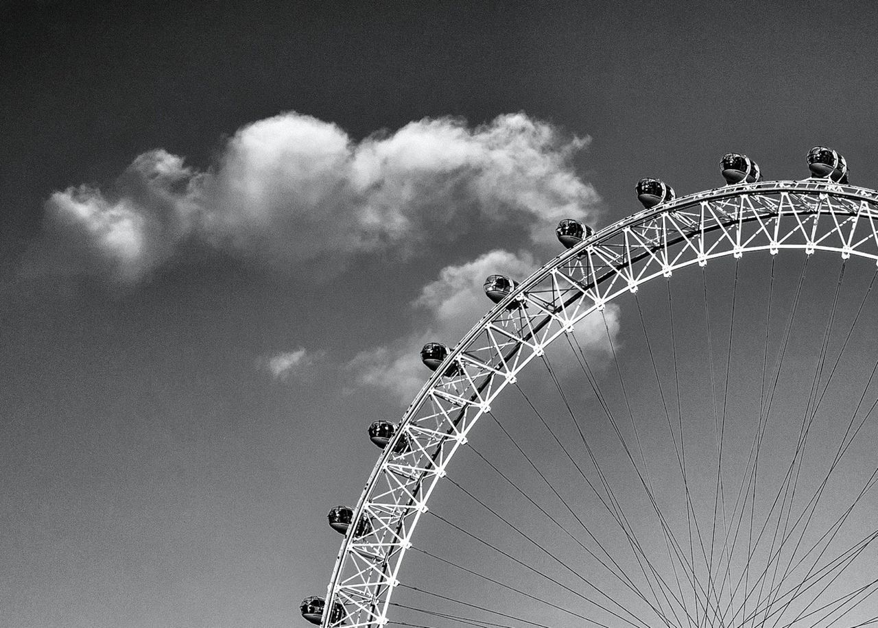 low angle view, amusement park, sky, amusement park ride, ferris wheel, arts culture and entertainment, decoration, lighting equipment, hanging, outdoors, no people, day, built structure, cloud - sky, design, illuminated, pattern, nature, chain swing ride, clear sky