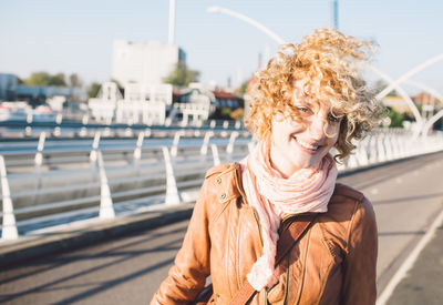 Portrait of smiling woman standing against sky