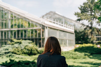 Rear view of woman standing against building