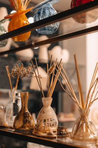 Beige glass bottles with wood stick aroma diffusers on wooden shelf. home decor. air freshener