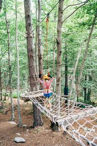 Man on tree trunk in forest