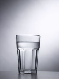 Glass of clear water on the gray background