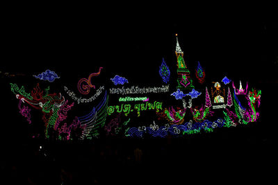 Low angle view of illuminated lighting equipment against sky at night