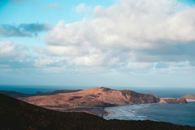 Scenic view of sea and mountains against sky