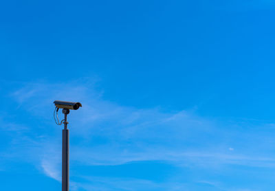 Low angle view of street camera against blue sky