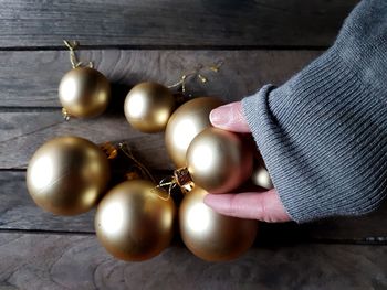 Cropped hand of woman holding bauble on table