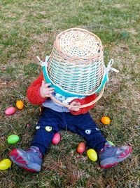 Toddler playing with basket during easter egg hunt