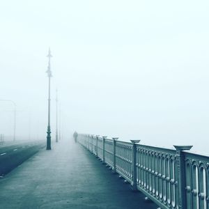 Bridge in foggy weather against sky