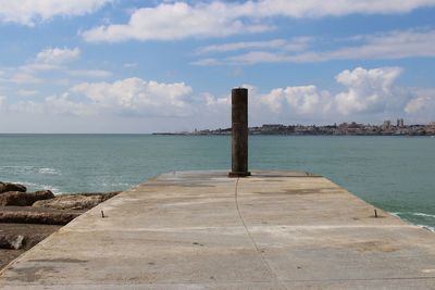 Pole at beach against sky