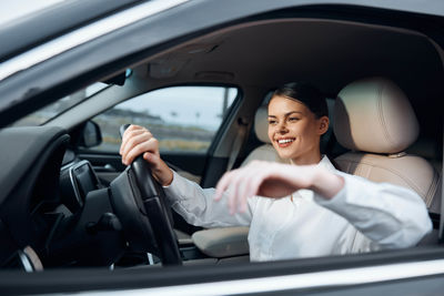 Portrait of young woman sitting in car