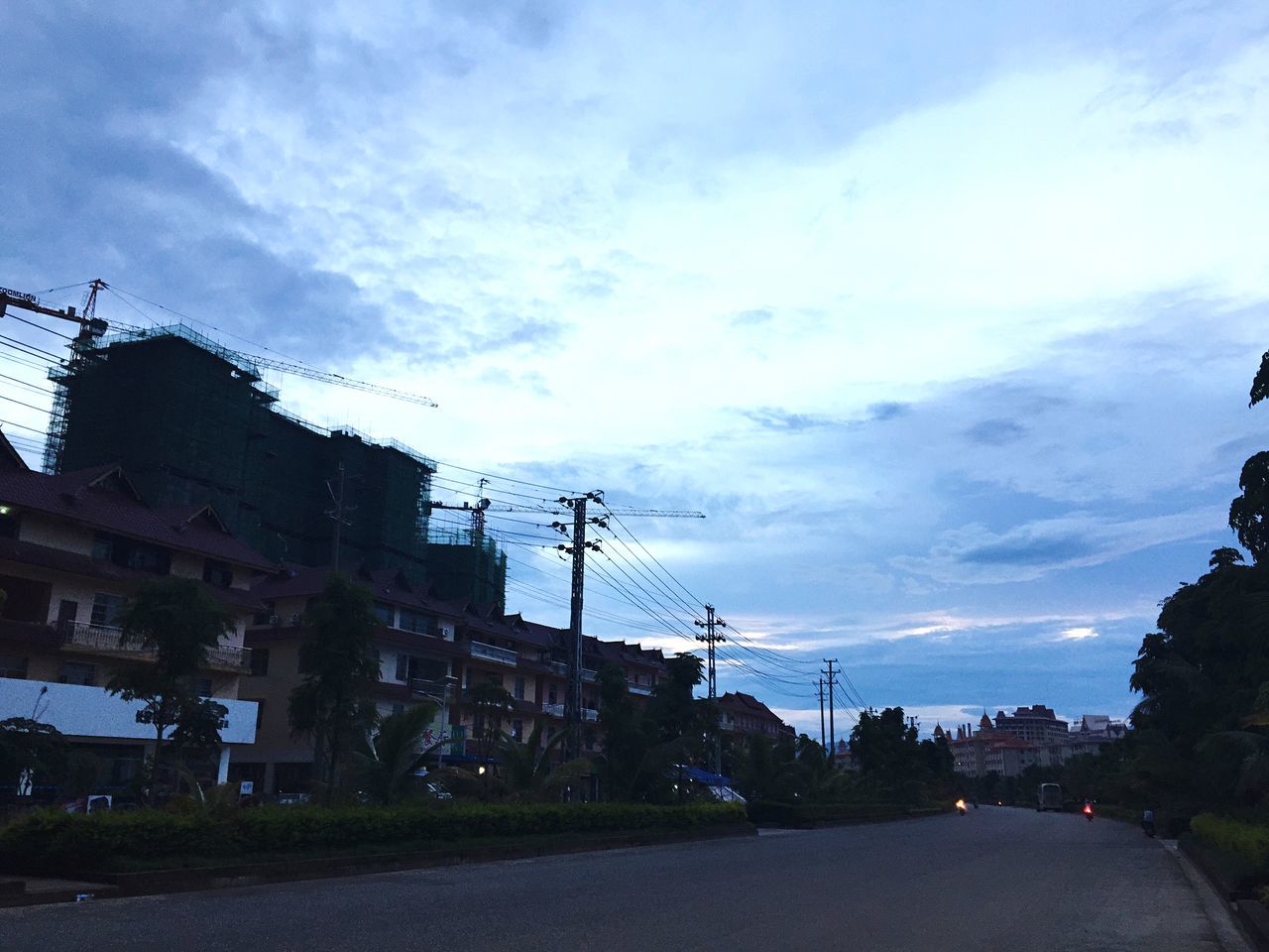 building exterior, architecture, built structure, sky, transportation, street, car, road, cloud - sky, the way forward, city, land vehicle, electricity pylon, house, residential building, power line, residential structure, cloud, cloudy, building