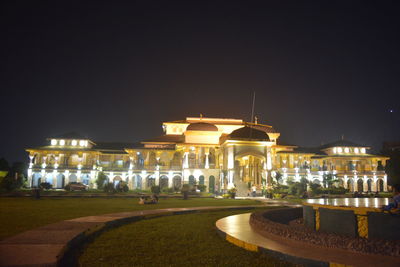 Illuminated building against sky at night