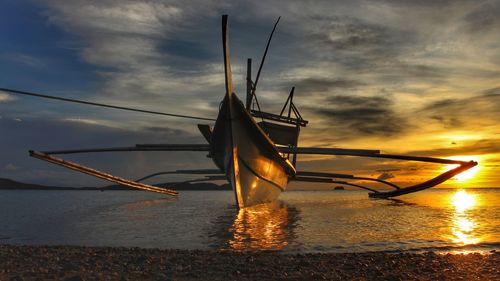 Ship in sea against sky during sunset