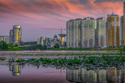 Panoramic shot of modern buildings against sky during sunset