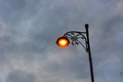 Low angle view of illuminated street light against sky