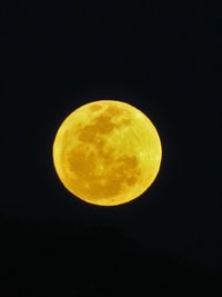 Close-up of yellow moon against black background