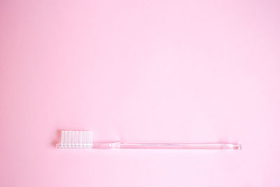 Close-up of toothbrush against pink background