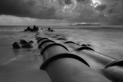 Low section of man on beach against sky